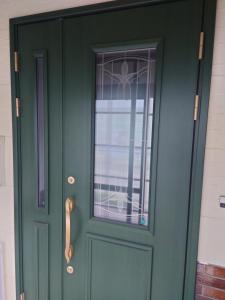 una puerta verde con una ventana en una casa en 玉川温泉の湯治に最適な宿　鳳凰館, en Senboku