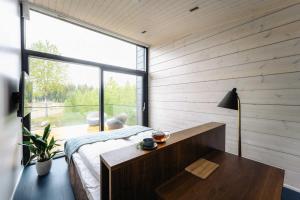 1 dormitorio con cama, mesa y ventana grande en PihlasResort en Joroinen