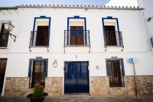 - un bâtiment blanc avec des portes et des fenêtres noires dans l'établissement Casa Mox en la Sierra de las Nieves, Paraíso del Senderismo, à Yunquera