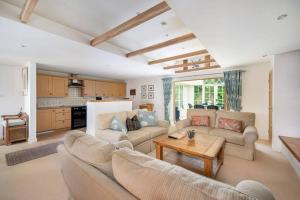 uma sala de estar com dois sofás e uma mesa em The Granary at Pannels Ash Farm em Sudbury