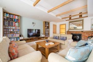 uma sala de estar com dois sofás e uma televisão em The Granary at Pannels Ash Farm em Sudbury