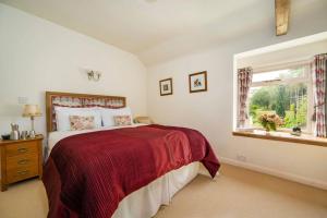 a bedroom with a large bed and a window at The Granary at Pannels Ash Farm in Sudbury