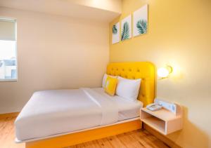 a bed with a yellow headboard in a room at Bloom Hotel - HSR Layout Sec 6 in Bengaluru