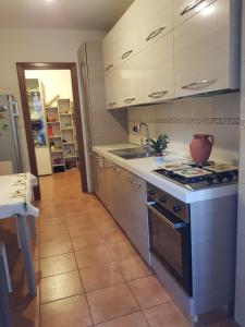 a kitchen with white cabinets and a stove top oven at EUR CHARME APARTMENT in Rome