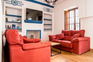 - un salon avec deux chaises rouges et une table dans l'établissement Casa Mox en la Sierra de las Nieves, Paraíso del Senderismo, à Yunquera