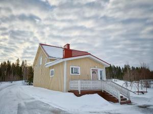 ein kleines Haus mit einer Terrasse im Schnee in der Unterkunft Mäki-mummola in Ylitornio