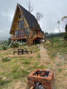 a large log cabin with a fire in front of it at Satha private villa Dieng in Banjarnegara