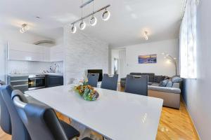 eine Küche und ein Wohnzimmer mit einem weißen Tisch und Stühlen in der Unterkunft Laudato XXL DELUXE in Turanj