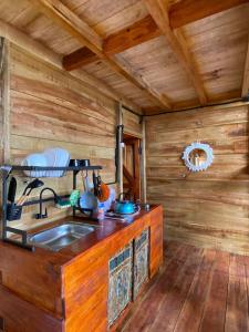 a kitchen with a sink and a wooden wall at Satha private villa Dieng in Banjarnegara