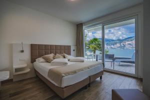 a bedroom with a large bed and a large window at Gabbiano in Malcesine