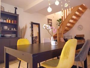 ein Esszimmer mit einem Tisch und gelben Stühlen in der Unterkunft CHEZ ISA chambres chez l'habitant in Montlouis-sur-Loire