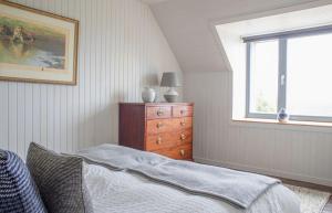 a bedroom with a bed and a dresser and a window at Taigh Druim in Elgol