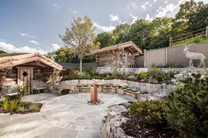 a garden with a stone patio and a log cabin at Alpenhof Murnau in Murnau am Staffelsee