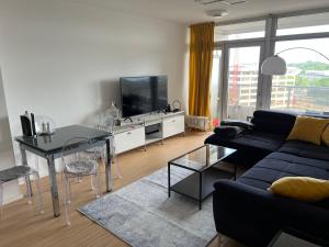 sala de estar con sofá azul y TV en Apartment Domblick, en Colonia