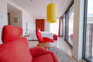 1 dormitorio y sala de estar con sillas rojas. en Avalon Hotel en Gotemburgo