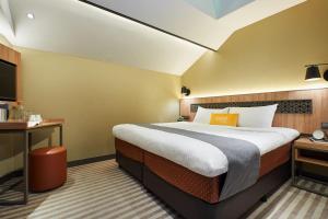 Una habitación de hotel con una cama grande y un televisor. en Dash Living Rochor, en Singapur