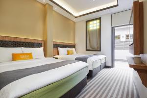 Una habitación de hotel con dos camas y una ventana. en Dash Living Rochor, en Singapur