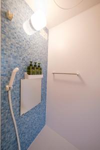 a bathroom with wine bottles on a shelf at Panari in Miyako Island