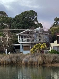 a house sitting next to a body of water at Anglesea Rivergums in Anglesea