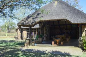 a large stone building with a grass roof at Letlotse Lodge in Hammanskraal