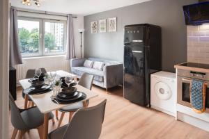 a kitchen and living room with a table and chairs at Olympic apartment - Stratford in London