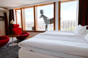 1 dormitorio con 1 cama blanca grande y sillas rojas en Avalon Hotel, en Gotemburgo