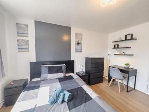 - une chambre avec un lit, un bureau et une chaise dans l'établissement Olympic apartment - Stratford, à Londres