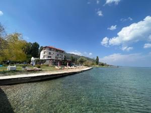un edificio sulla riva di uno specchio d'acqua di Hotel Victoria a Pogradec