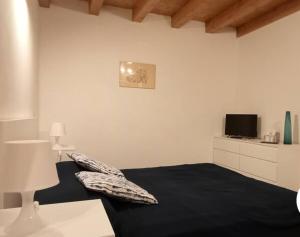 a bedroom with a black bed and a tv at b&b La Divina Pietra 