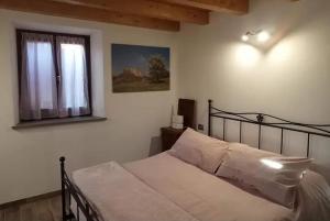 a bedroom with a bed and a window at b&b La Divina Pietra in Carnola
