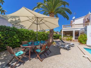 a patio with a table with an umbrella and chairs at Villa antonio in Can Pastilla