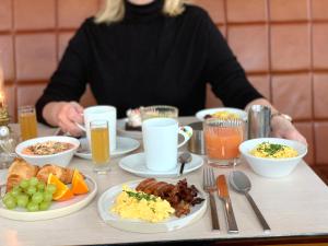 une personne assise à une table avec des assiettes de nourriture dans l'établissement Avalon Hotel, à Göteborg