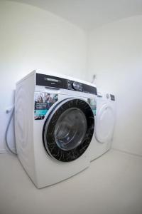 uma máquina de lavar roupa branca com fundo branco em Scharnitz Chalet - gut eingerichtetes Haus em Scharnitz