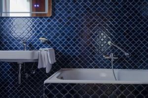 un bagno blu con vasca e lavandino di Scharnitz Chalet - gut eingerichtetes Haus a Scharnitz