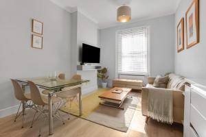 a living room with a couch and a table at Phaedrus Living: South Kensington Luxury Flat in London