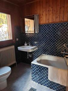 e bagno con servizi igienici, vasca e lavandino. di Scharnitz Chalet - gut eingerichtetes Haus a Scharnitz