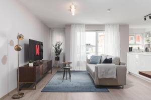 een woonkamer met een bank en een tafel bij DELUXE APARTMENT 2 Schlafzimmer - kostenlos Parken - Messe Flughafen - Balkon - Netflix in Leinfelden-Echterdingen