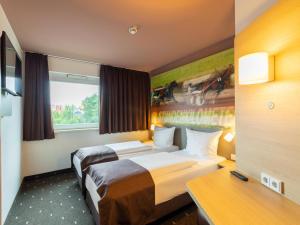 a hotel room with two beds and a window at B&B Hotel Mönchengladbach in Mönchengladbach