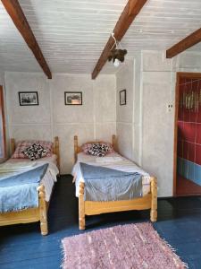 a bedroom with two beds and a rug at Beli Kamen etno selo in Prokuplje