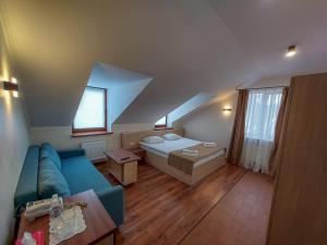 uma sala de estar com um sofá azul e uma cama em Graff Hotel em Dnipro