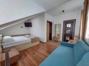 1 dormitorio con 1 cama y 1 sofá azul en Graff Hotel, en Dnipro