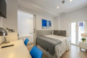 1 dormitorio con cama, escritorio y mesa en AmazINN Places Blasco de Garay 102, en Madrid