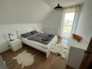 a white bedroom with a bed and a window at Bokorlak 3 in Odorheiu Secuiesc