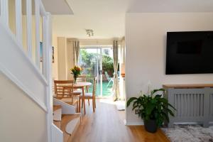 倫敦的住宿－Modern House near Canary Wharf, Excel, Greenwich，客厅配有电视和桌椅