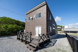 a tiny house with a staircase leading up to it at トワイライトヒルズ Twilight Hills in Motobu