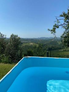 a blue swimming pool with a view of the countryside at Casa Quinterni in Alba