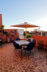 einen Tisch und Stühle mit Sonnenschirm auf einer Terrasse in der Unterkunft AZAWAN HOUSE in Tamraght Ouzdar