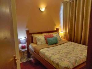 una camera da letto con un letto con cuscini sopra di Lovely Apartment in Westlands a Nairobi