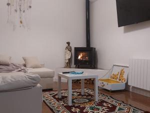 a living room with a table and a fireplace at La Quibla de Abuhan in Caudé