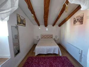 - une chambre avec un lit et un tapis rose dans l'établissement La Quibla de Abuhan, à Caudé